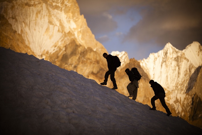 7. Expedition members meander between crevasses with the Gasherbrum IV massif visible in the background